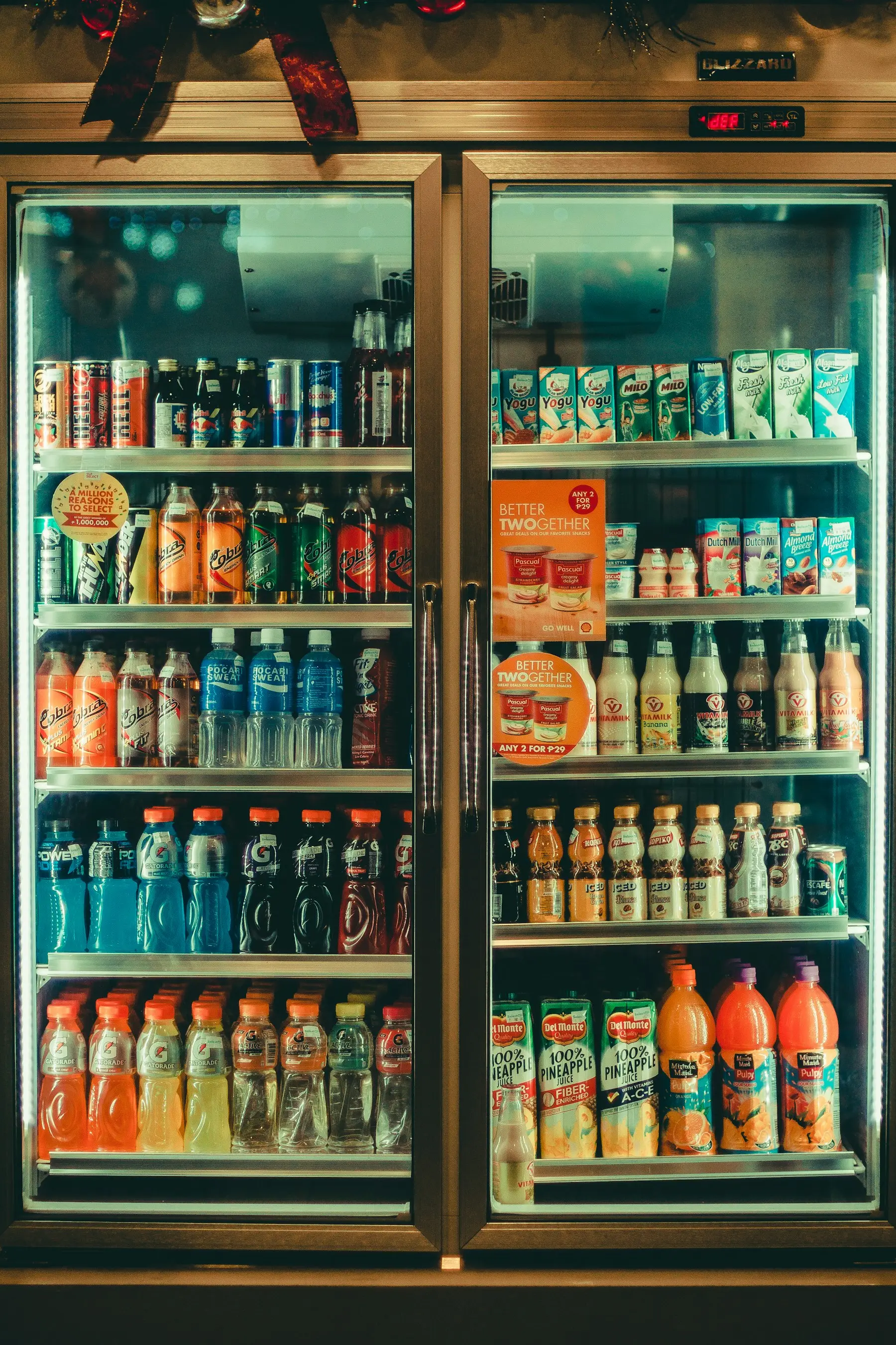 A glass-door refrigerator full of bottled and canned drinks